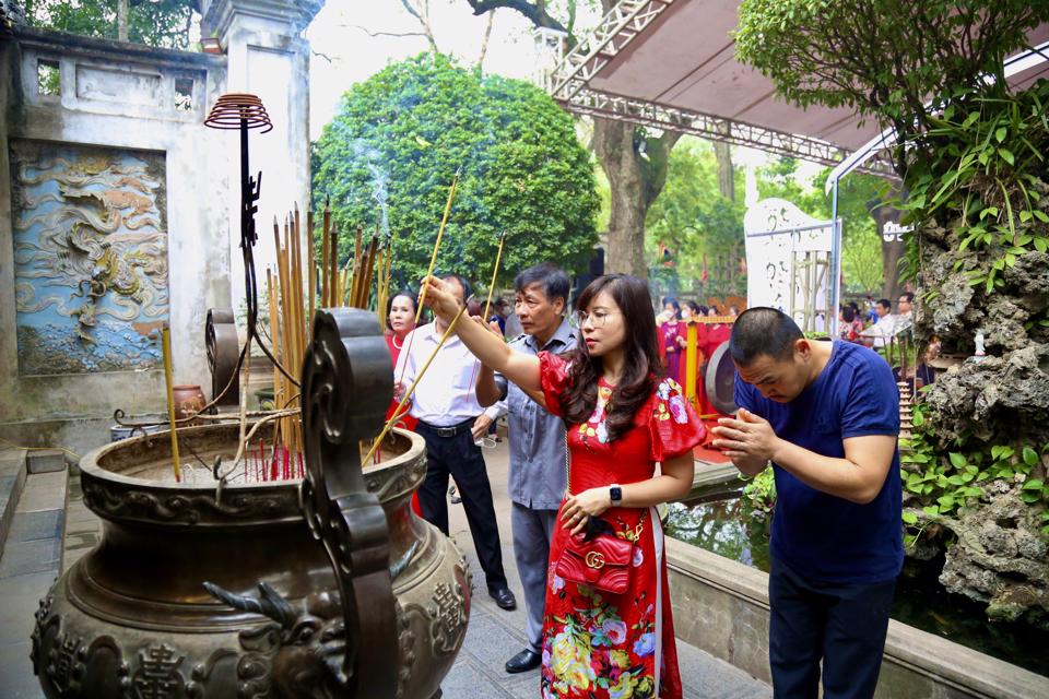  Visitors to Quan Thanh Temple offer incense to commemorate the ancient Vietnamese genie. Photo: Duy Minh